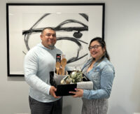 Couple holding a gift basket and and smiling.