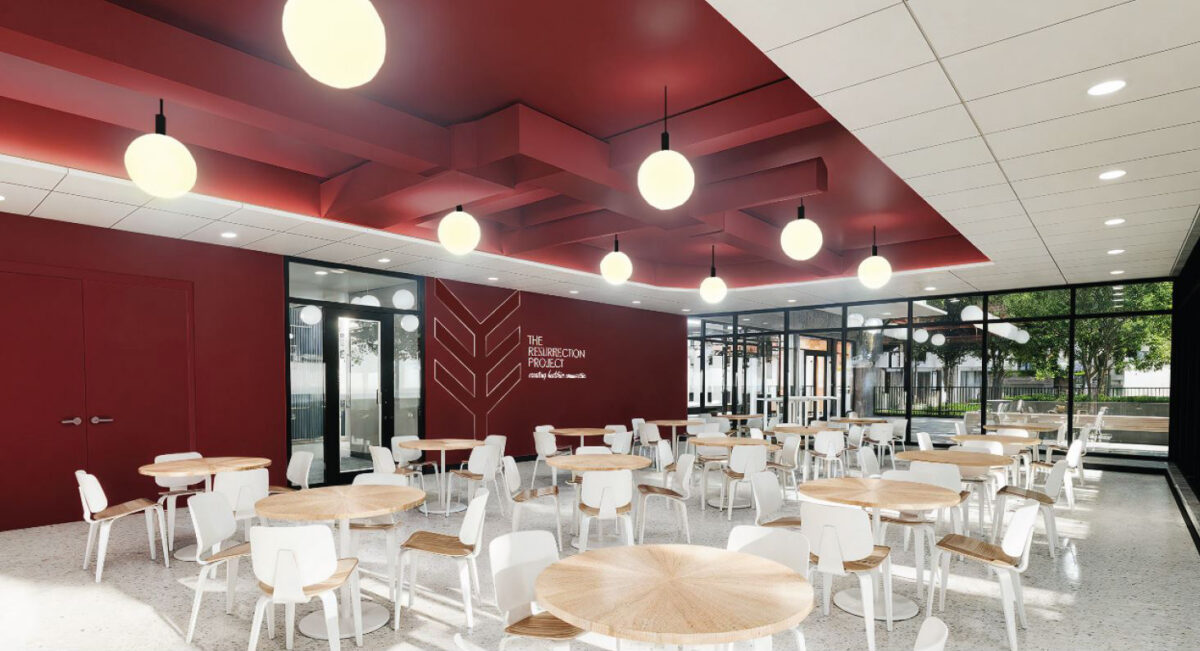 Cafeteria like floor with red wall and filled with tables and chairs.