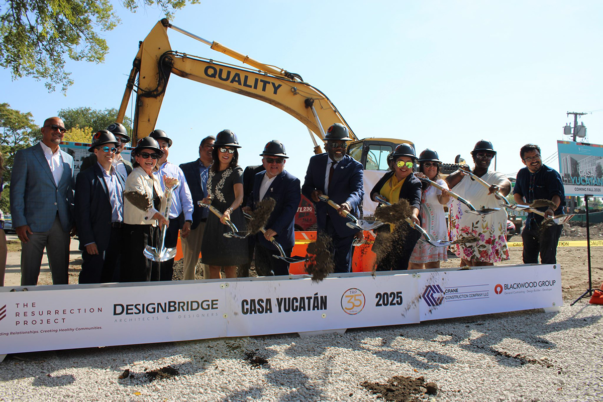 Casa Yucatan groundbreaking. People with shovels and crane in the background.
