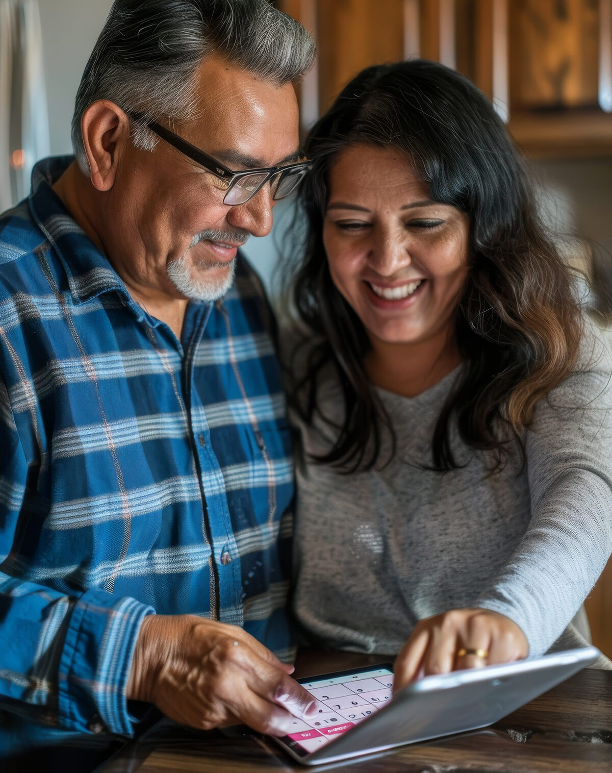 a Hispanic couple organizing their day together with a shared digital calendar on a tablet