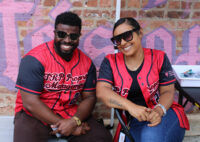 TRP Property Management staff, man and woman, sitting and smiling at camera wearing TRP jerseys.
