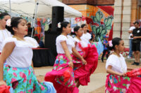 Young girls performing a traditional Mexican dance with colorful skirts.